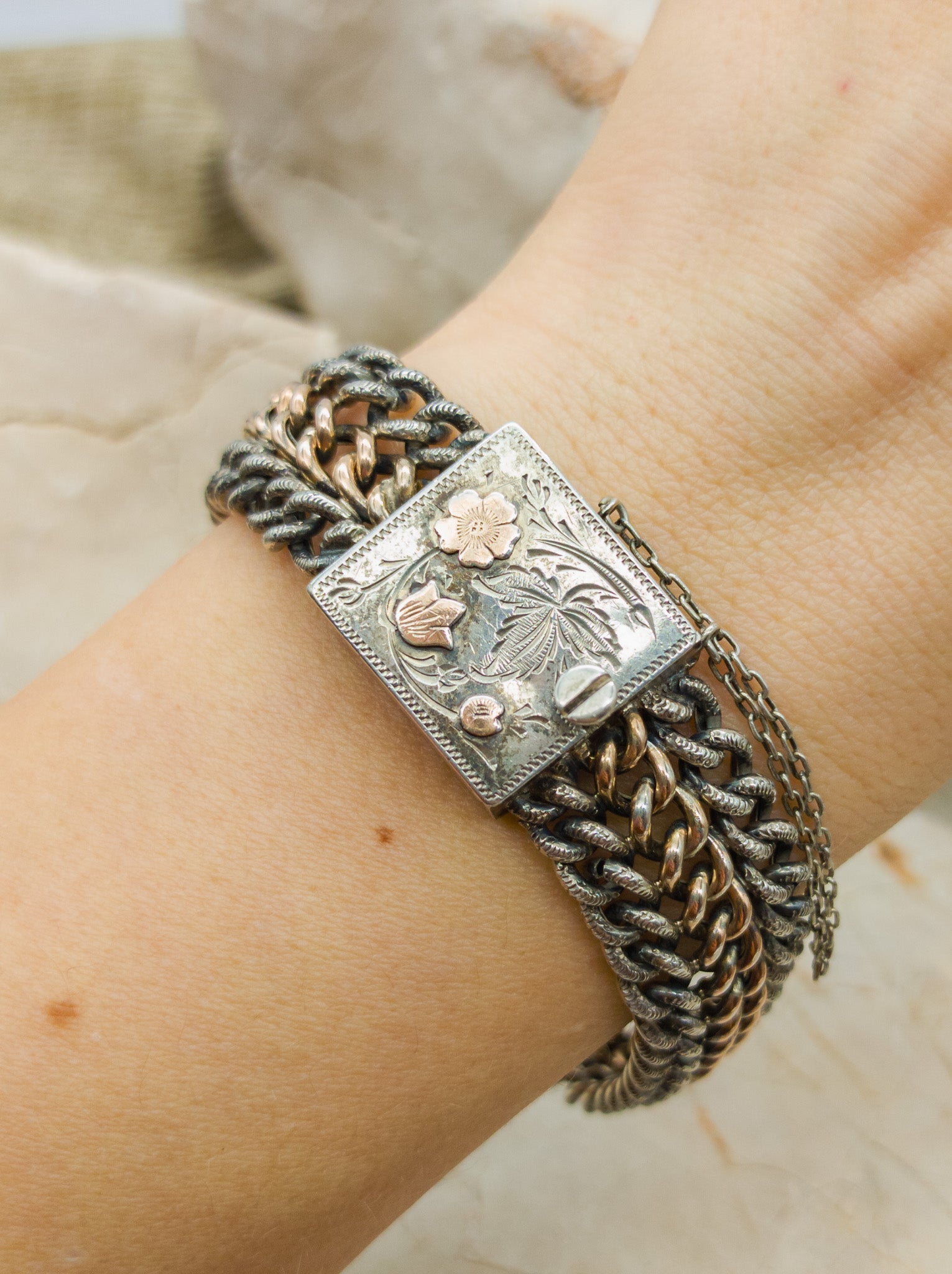 Victorian Silver repoussé chain bracelet with box clasp and rose gold plated details. on arm