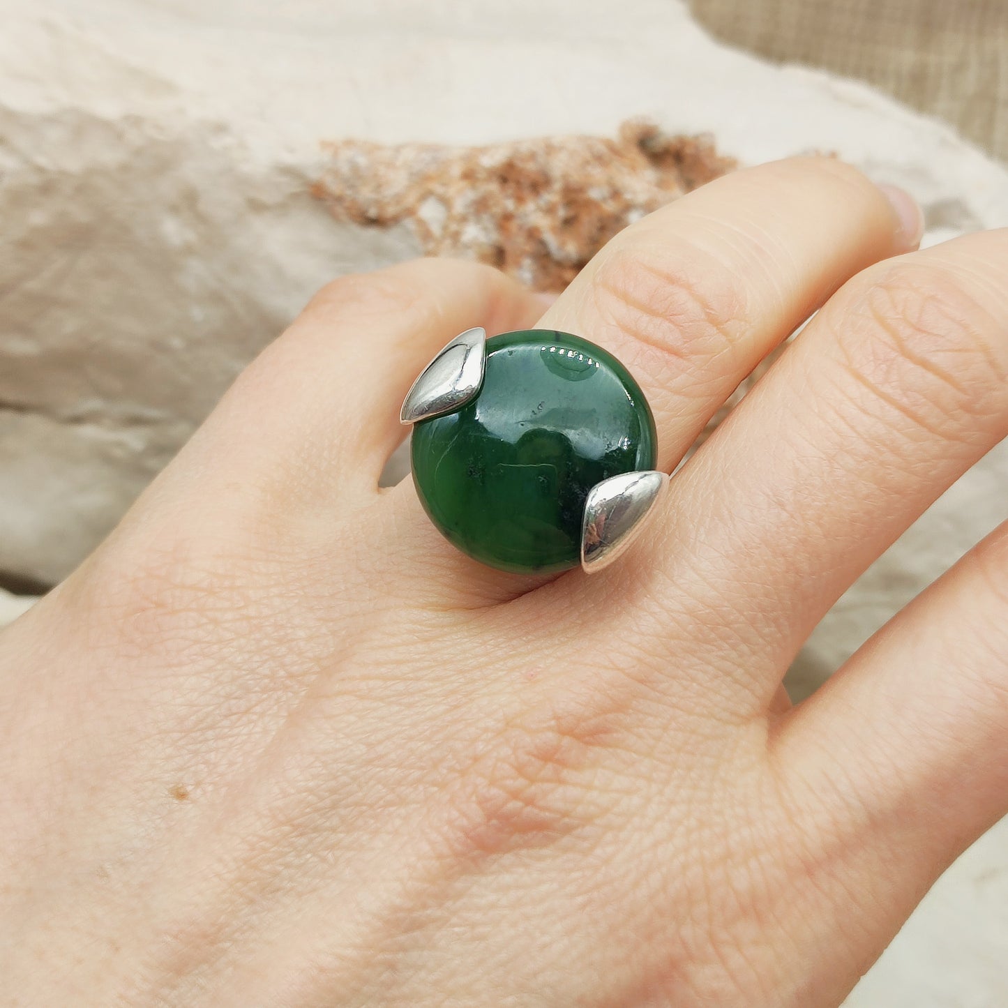 Ring gedragen aan de hand met grote groene steen