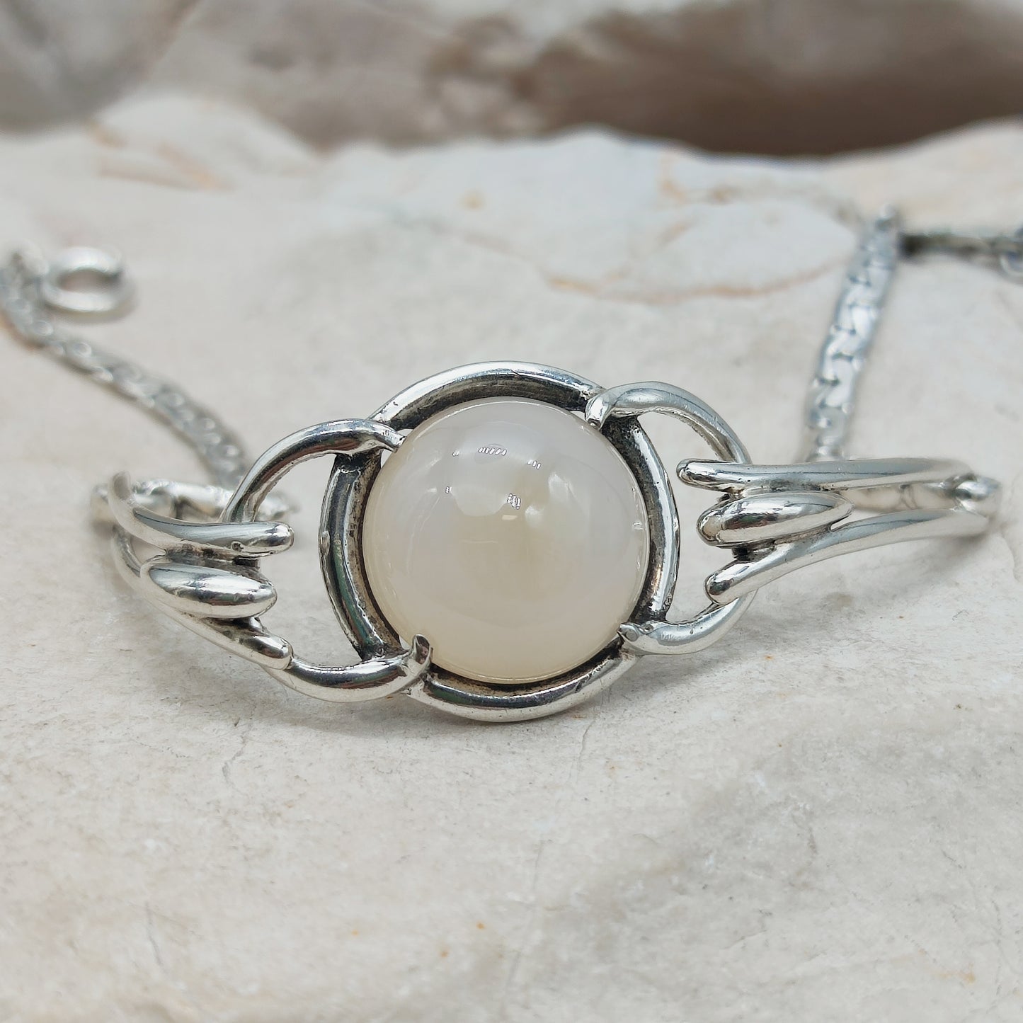 Detail van melkachtige cabochon in ronde zilveren zetting