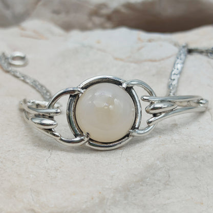 Detail van melkachtige cabochon in ronde zilveren zetting