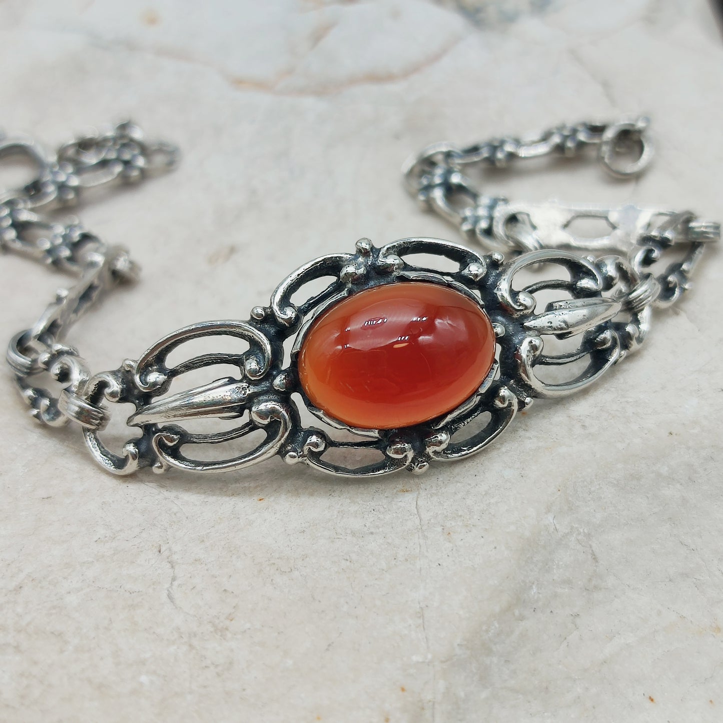 Detail van de cabochon geslepen carneool in zilveren zetting