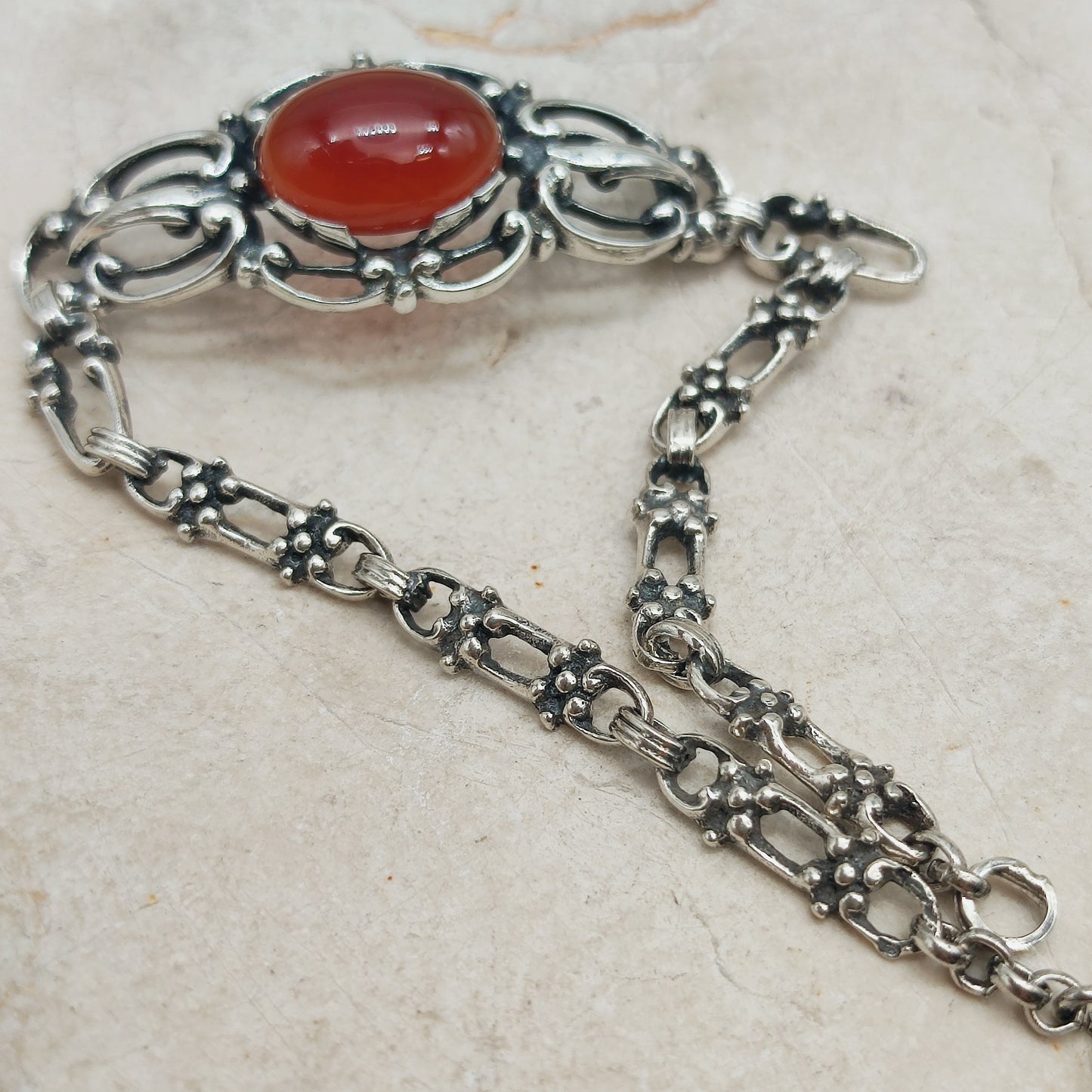 Opengewerkte zilveren schakels met decoratieve details