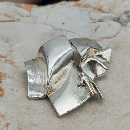 Zijaanzicht van de geplooide zilveren vorm