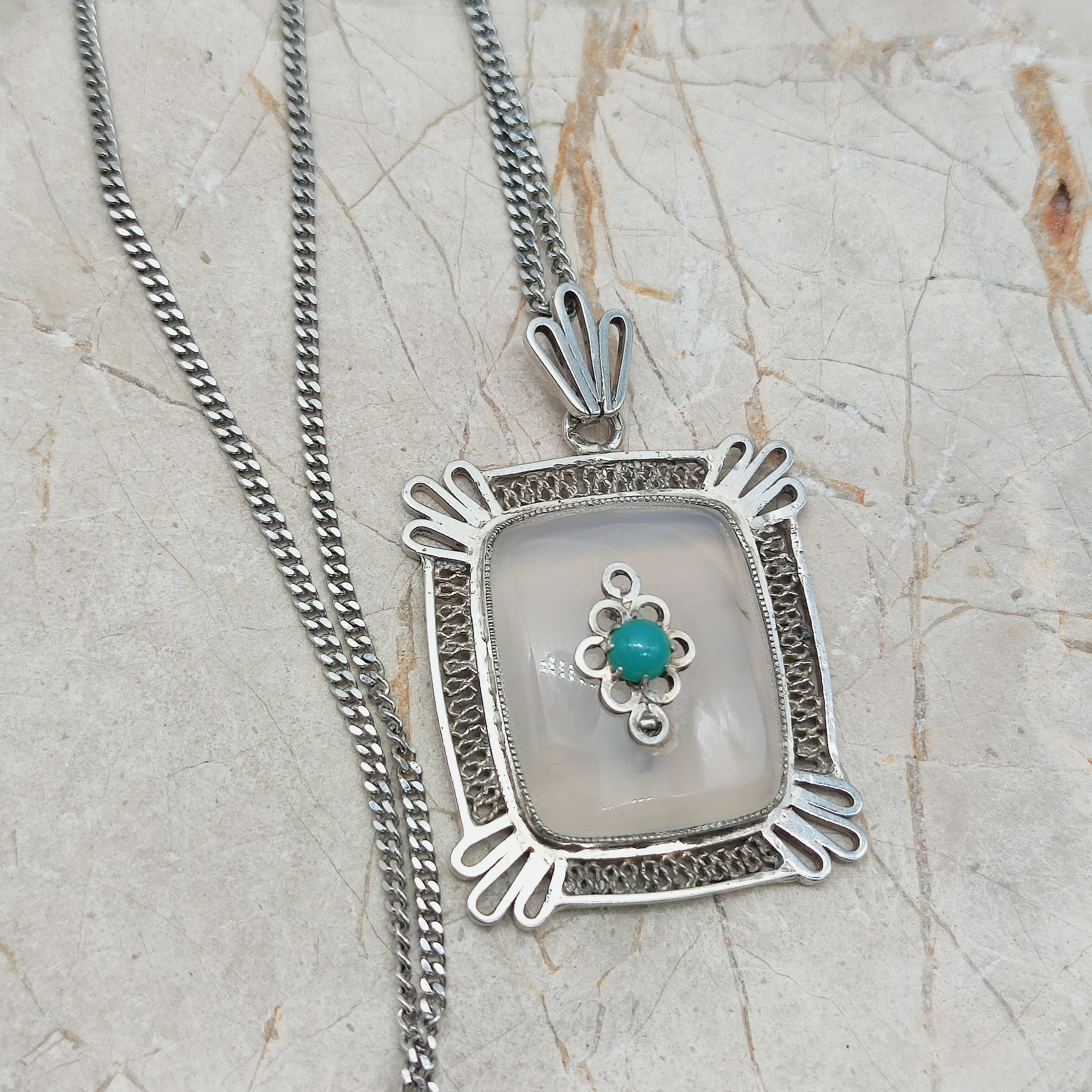 Vintage hanger gedragen aan zilveren schakelketting