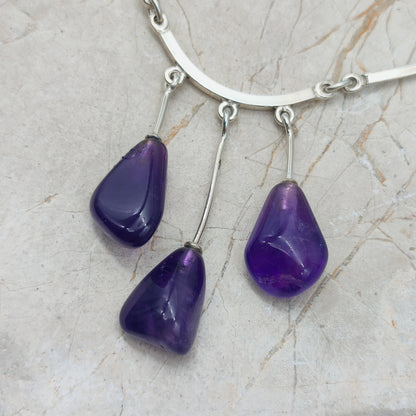 Detail van de amethist hangers aan gebogen zilveren staaf