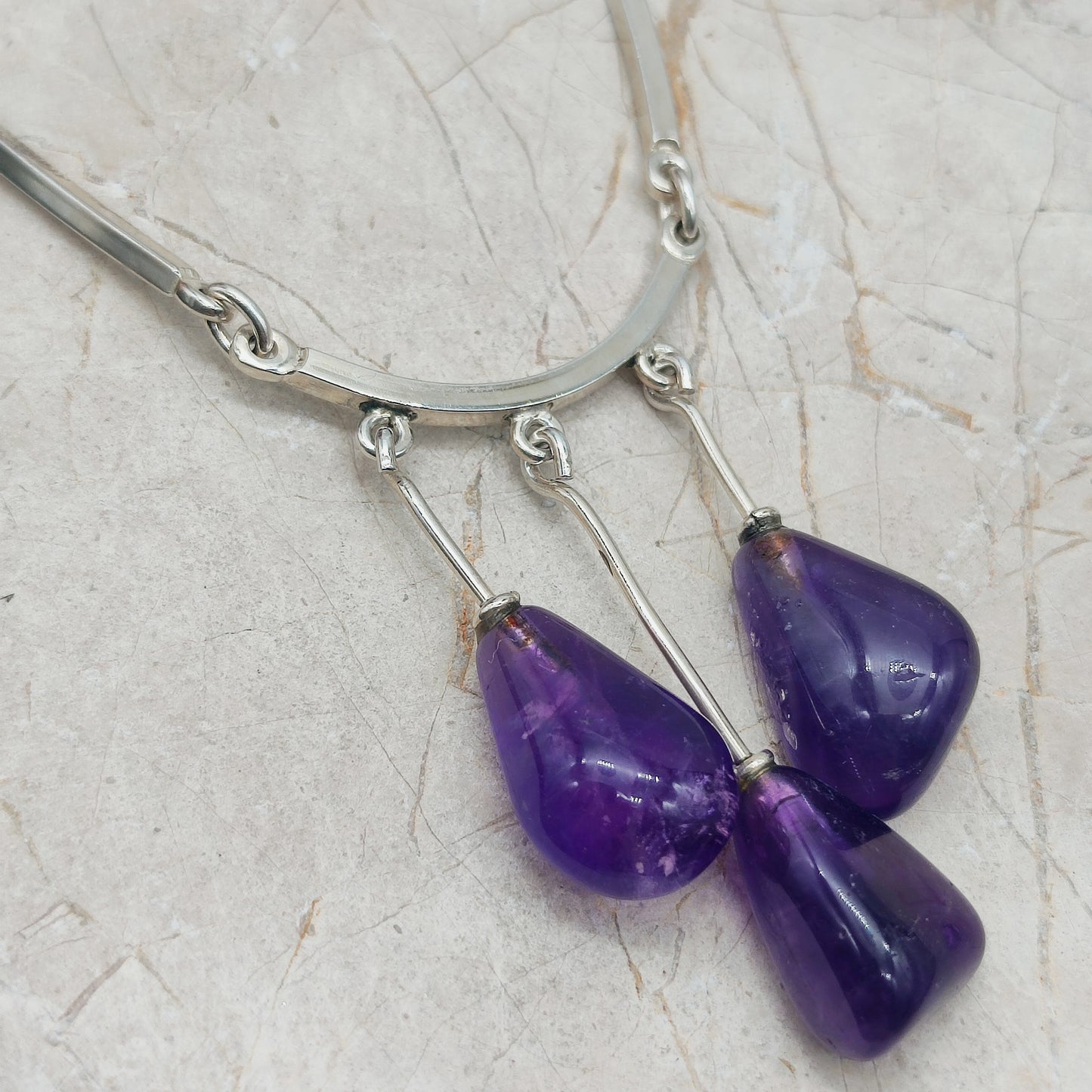 Detail van zilveren staafelementen van de ketting