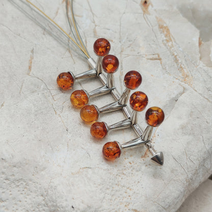 Detail bewegende amber elementen in jaren 70 kinetische hanger