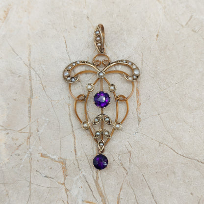 Antique Edwardian gold lavaliere pendant with seed pearls and amethyst centre stone.