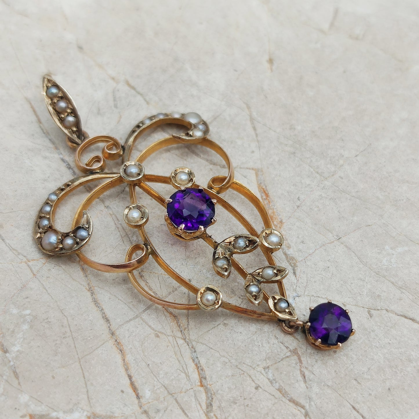 Detail of Edwardian lavaliere pendant with seed pearls and amethyst drop in 9ct gold.