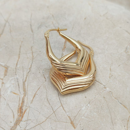 Close-up van vintage 9ct gold hoop earrings UnoAErre met ribbelstructuur