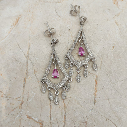 Detail van witgouden oorbellen met bewegende diamant hangers