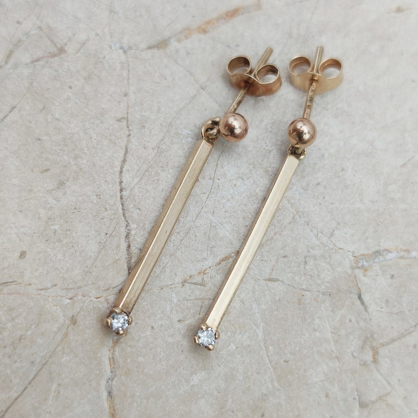 Close-up van vintage 9ct gouden bar drop oorbellen met diamant