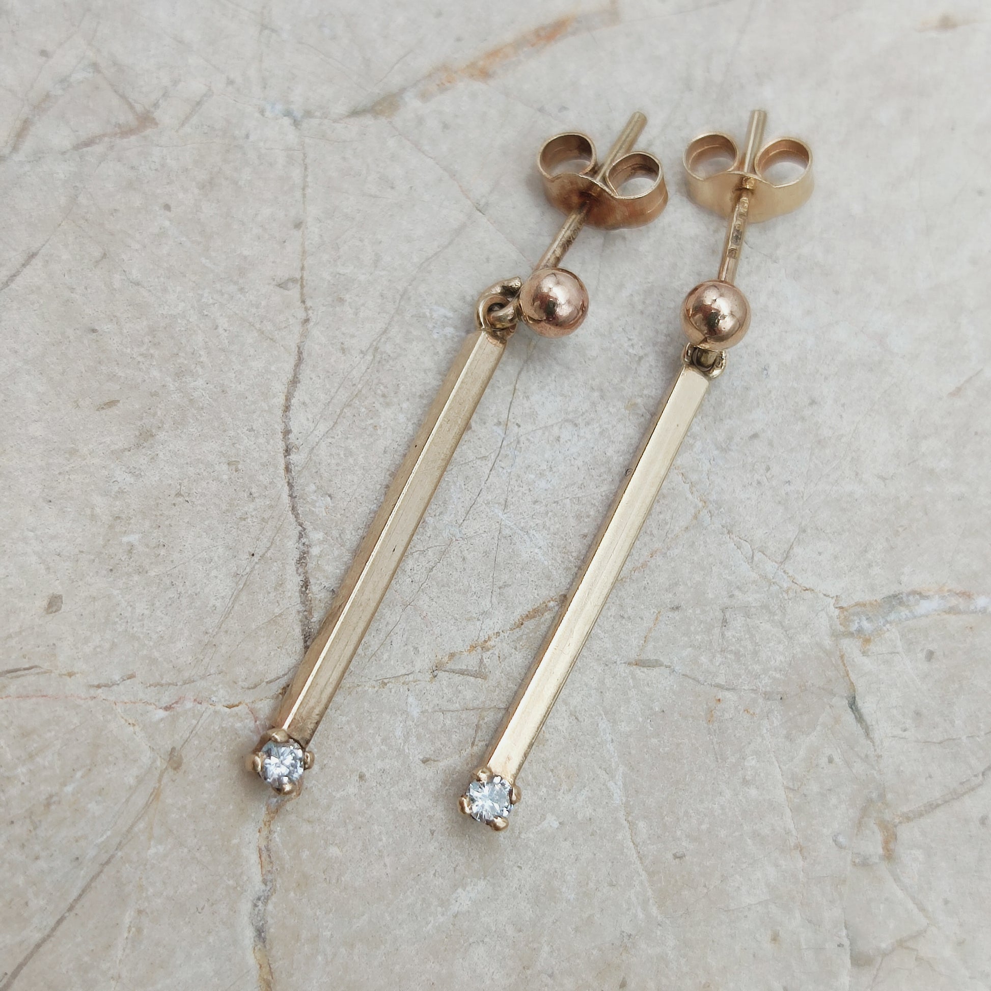 Close-up van vintage 9ct gouden bar drop oorbellen met diamant
