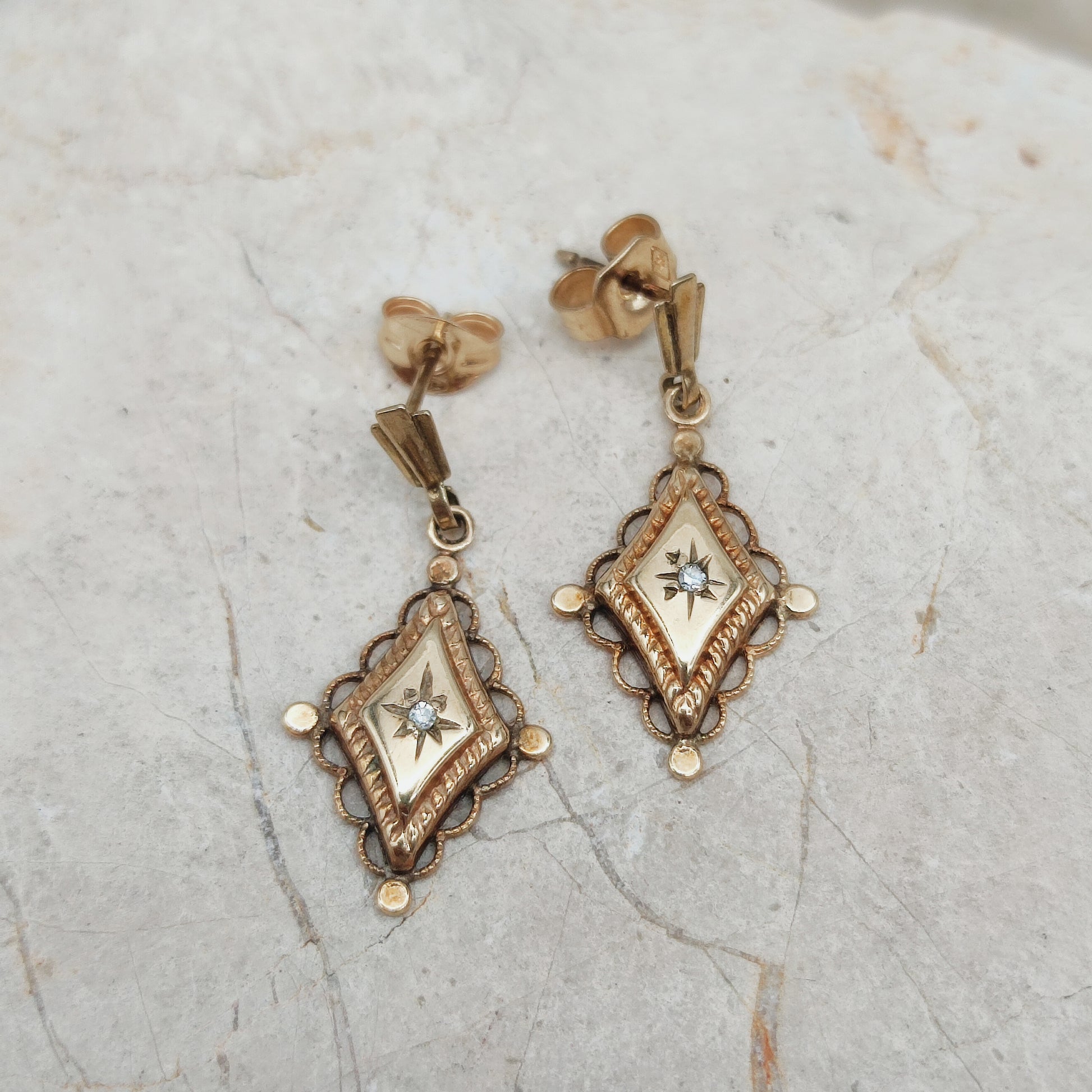 Close-up van antieke diamond drop earrings met star setting