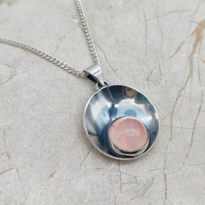 Zilveren hanger met rozekwarts en ketting op lichte achtergrond