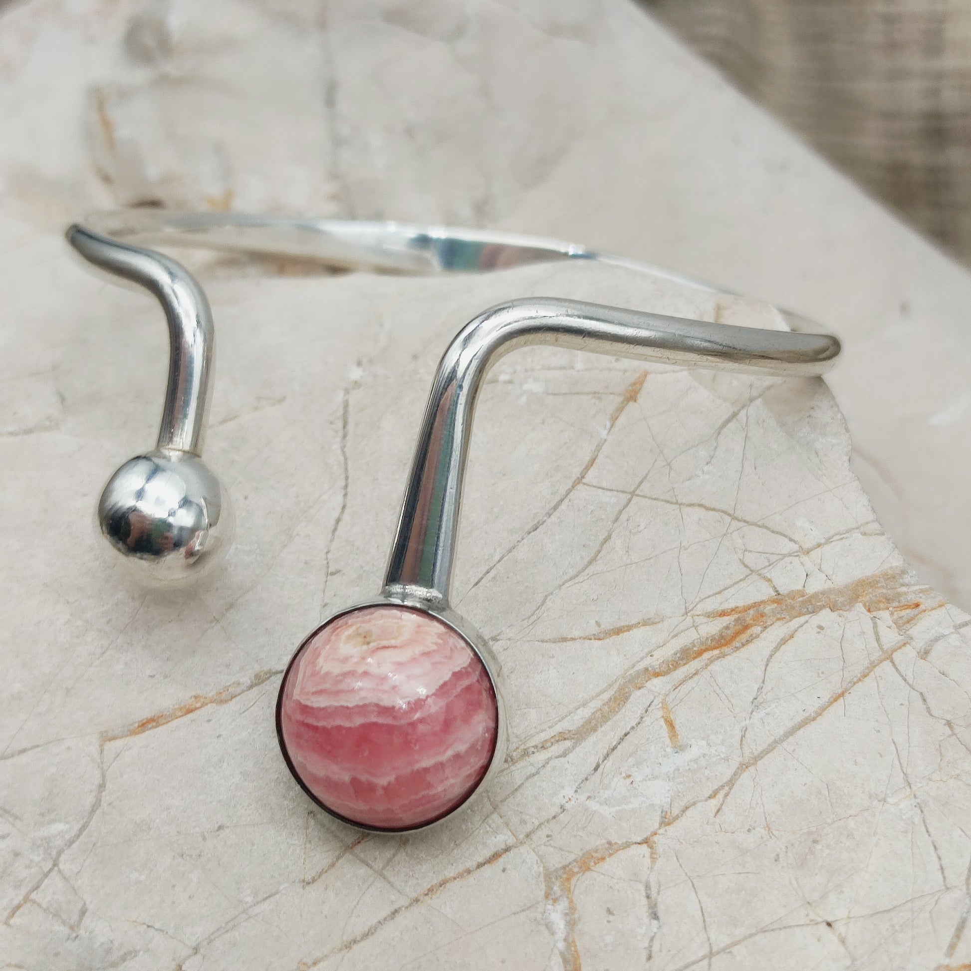 Detail van zilveren armband met bol en rhodochrosiet steen