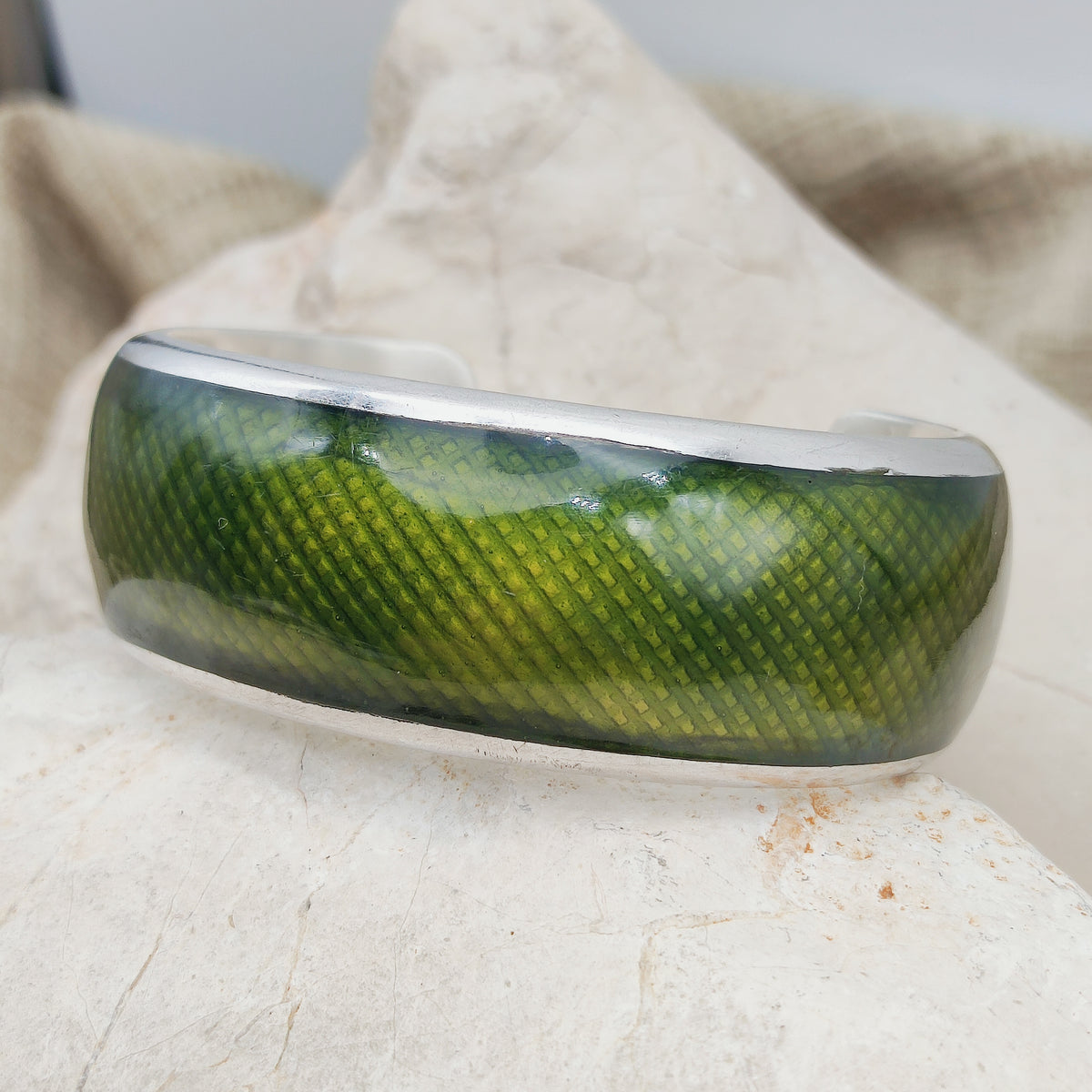 Zijaanzicht van een zware zilveren Gori armband met donkergroen email.
