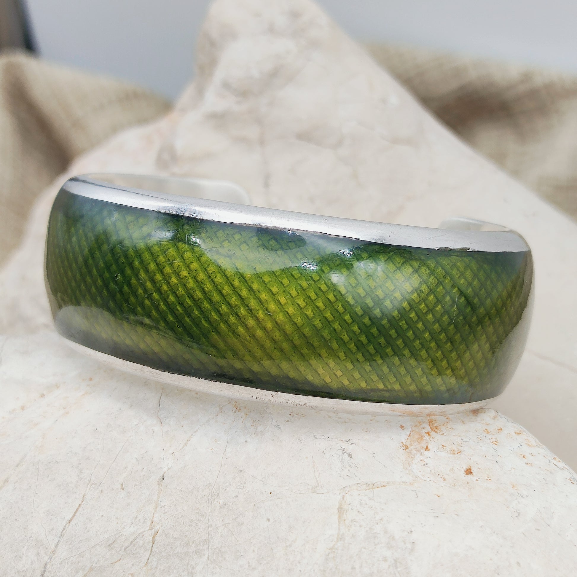 Zijaanzicht van een zware zilveren Gori armband met donkergroen email.