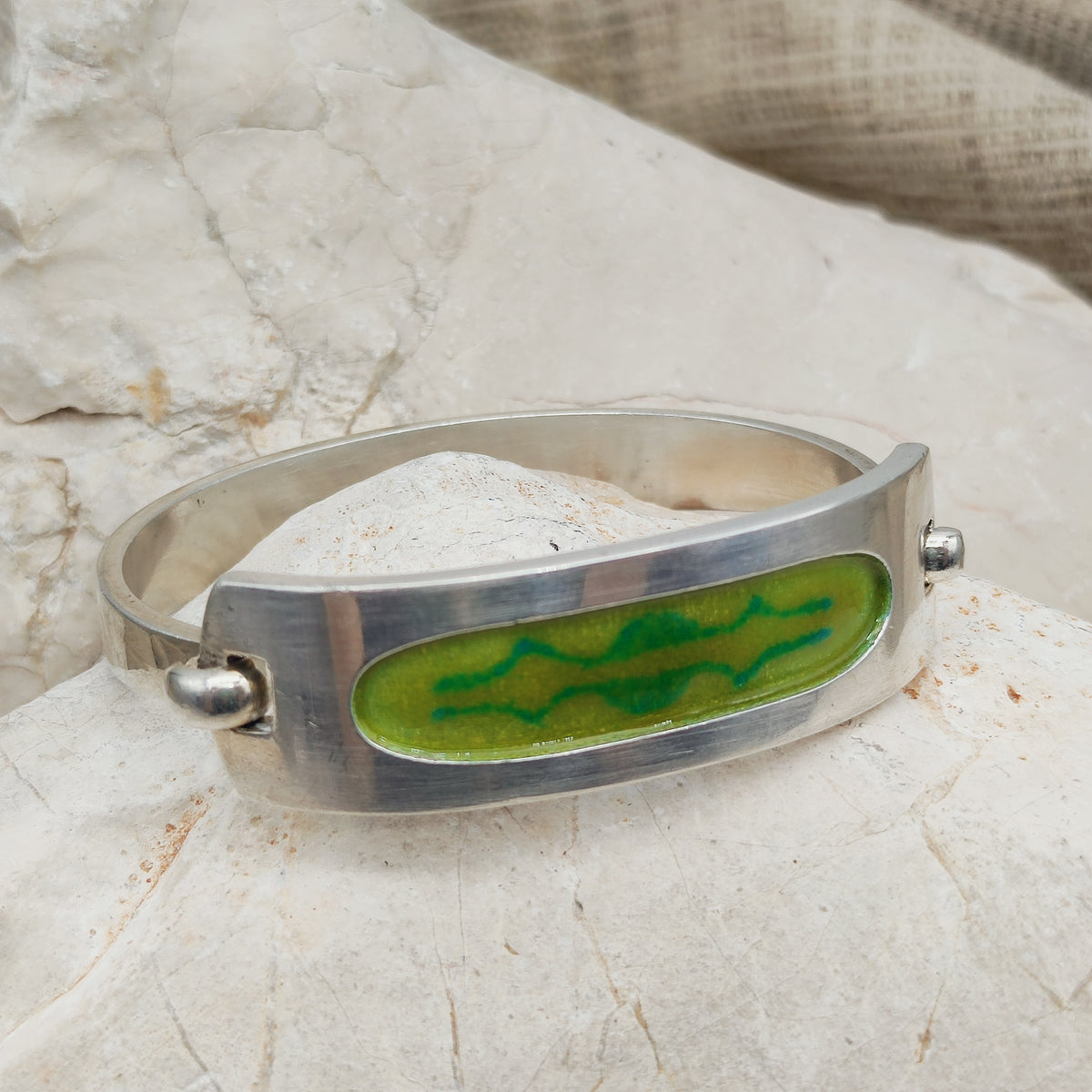 Vintage armband in Frans gekeurd 800 zilver met een brede bovenplaat en groen email in twee tinten, gesigneerd SIK.