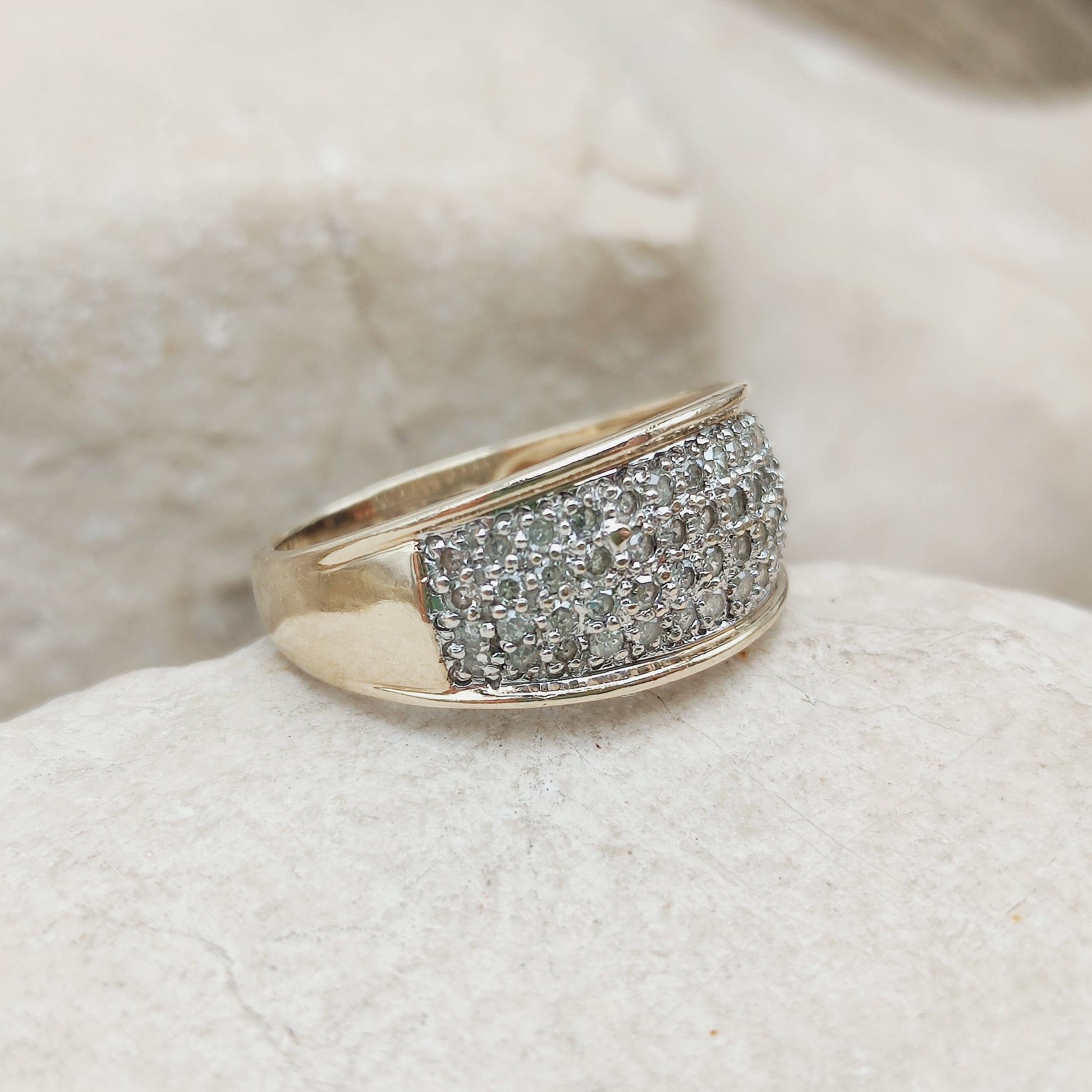 Zijaanzicht van de brede gouden pavé ring