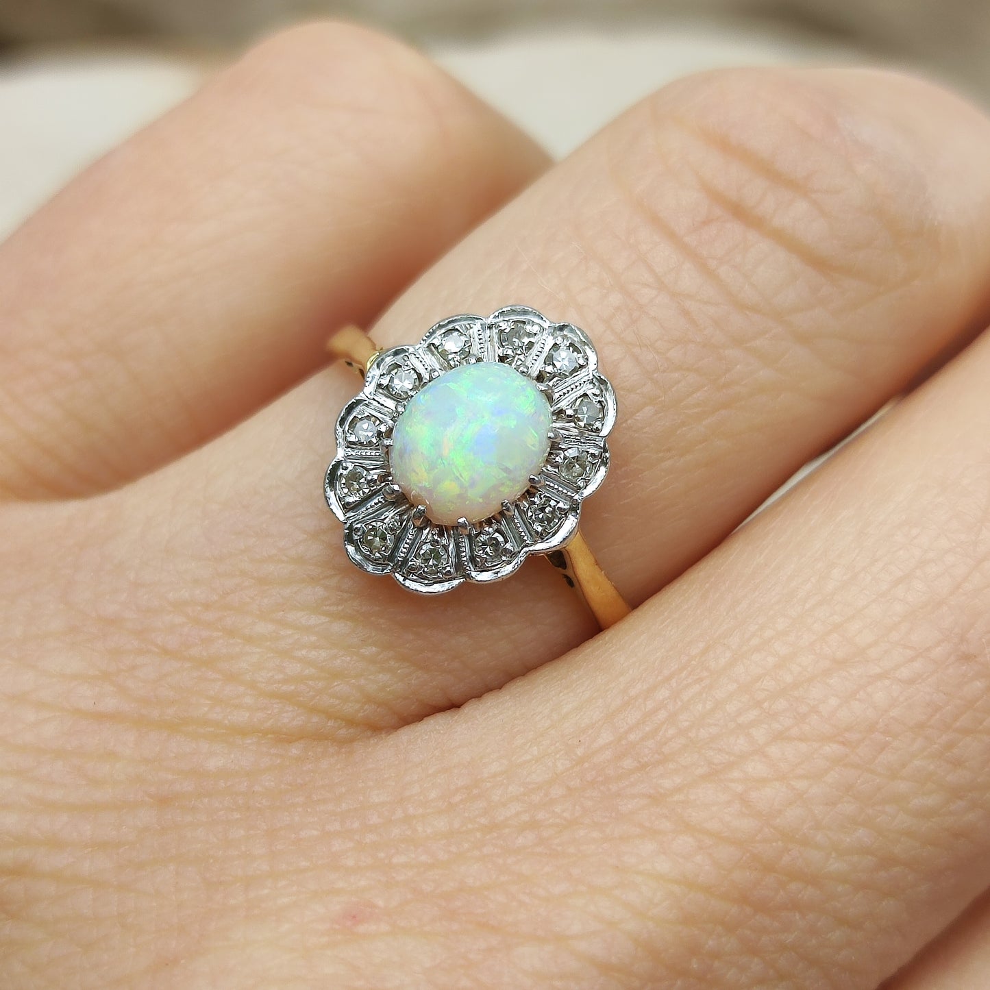 Vintage opaalring met diamant gedragen aan de hand