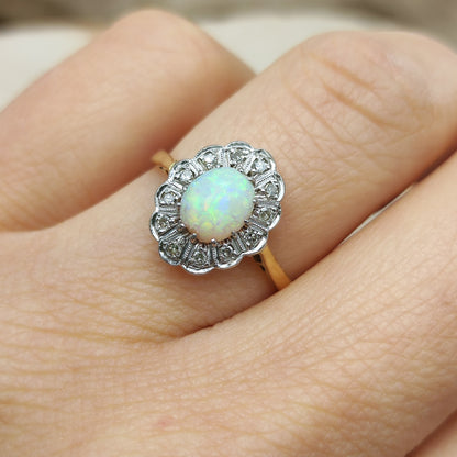 Vintage opaalring met diamant gedragen aan de hand