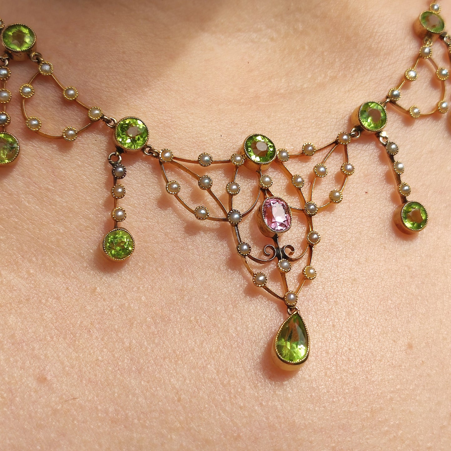 Detail van roze topaas in antieke gouden halsketting met milgrainzetting