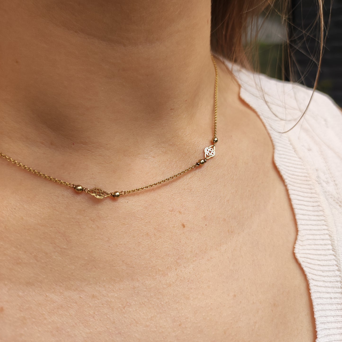 Fijne 8 karaat gouden schakelketting gedragen rond de hals