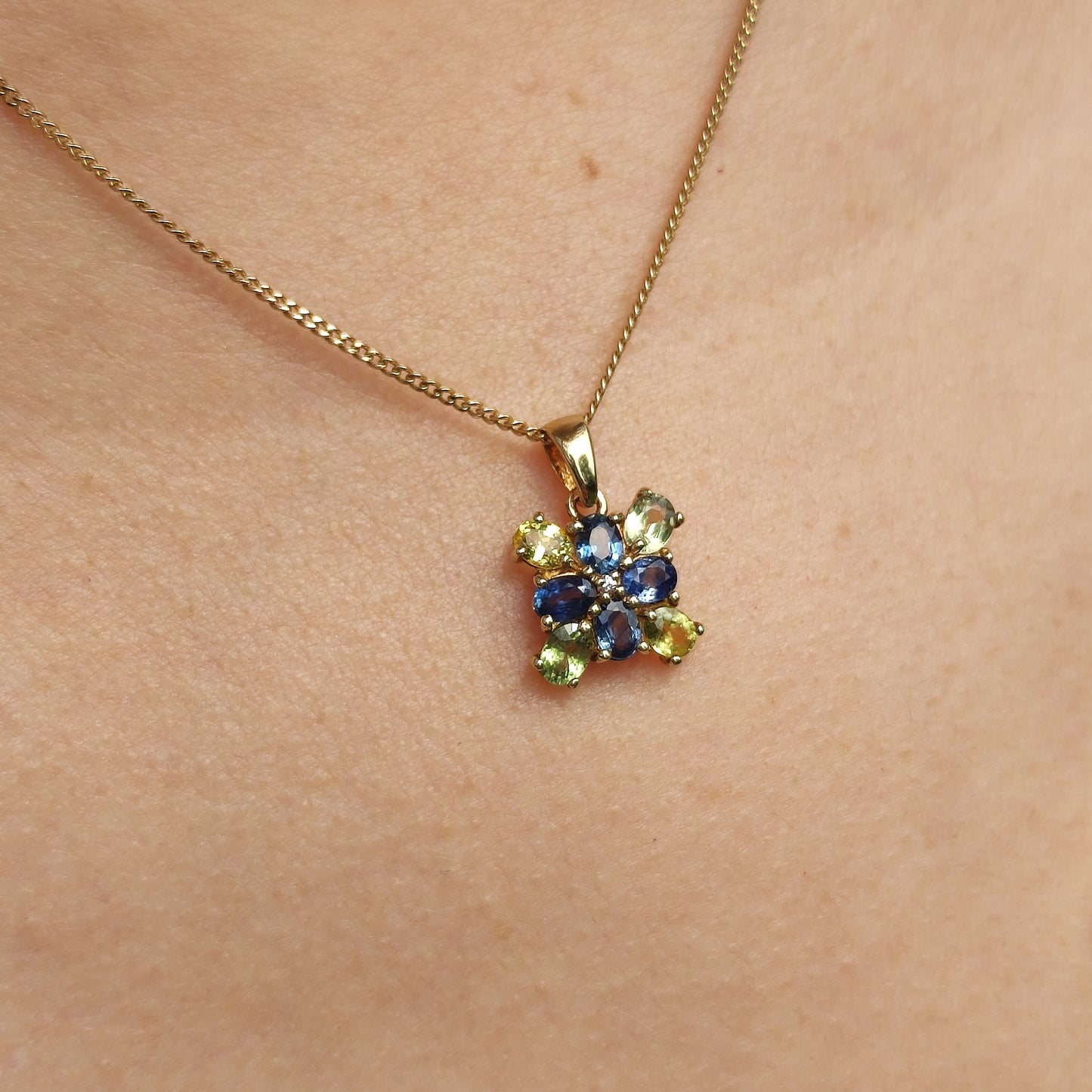 9 karaat gouden hanger met meerkleurige saffieren gedragen aan een ketting