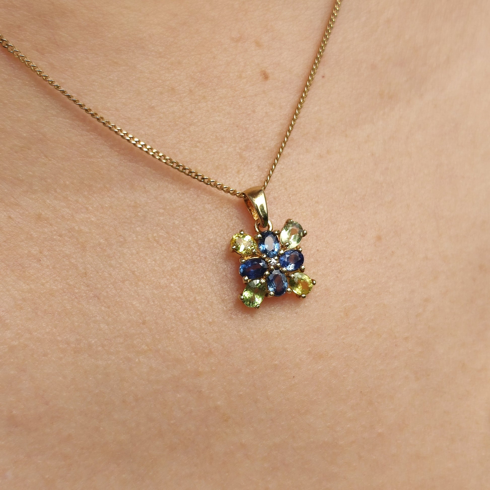 9 karaat gouden hanger met meerkleurige saffieren gedragen aan een ketting