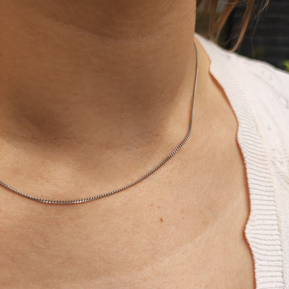 Fijne 14 karaat witgouden gourmetketting gedragen rond de hals