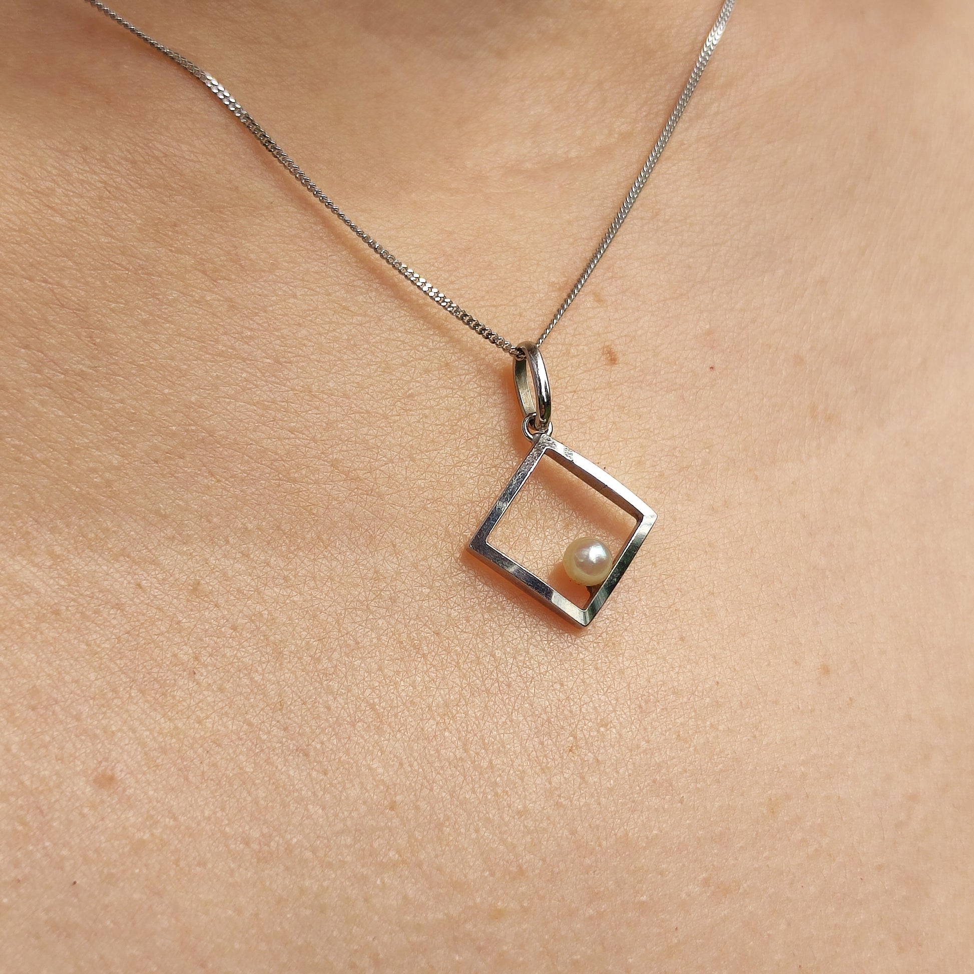 Vintage 18 karaat witgouden hanger met Akoya parel gedragen aan een ketting
