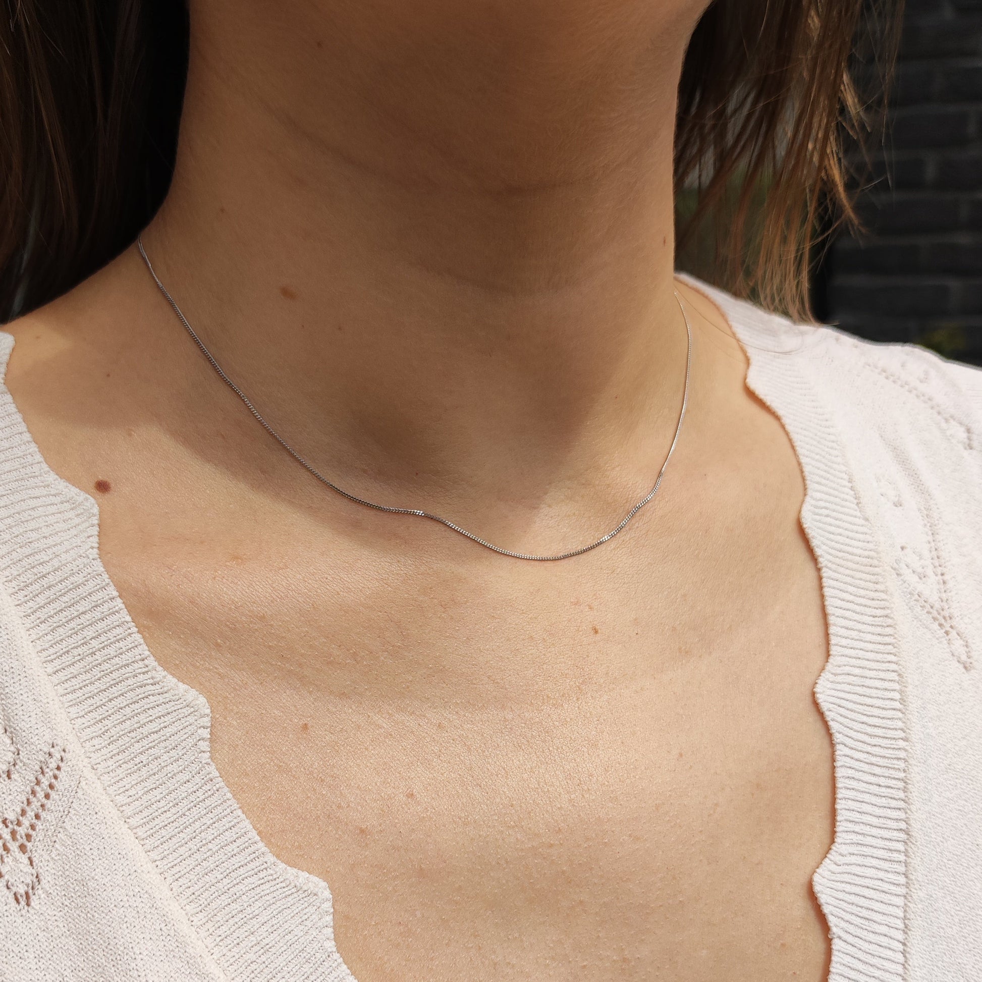 Fijne 18 karaat witgouden gourmetketting gedragen rond de hals
