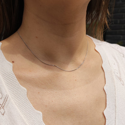 Fijne 18 karaat witgouden gourmetketting gedragen rond de hals