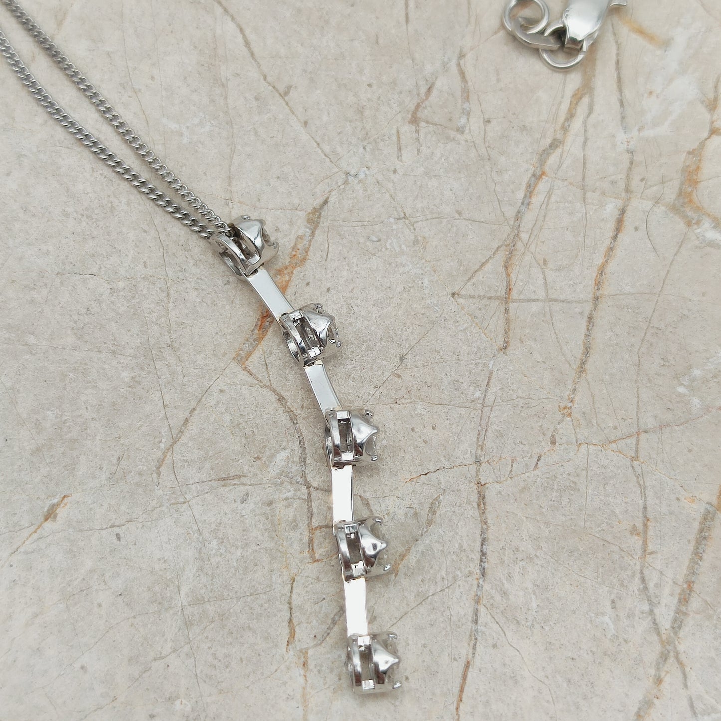 Zijaanzicht van witgouden hanger met verhoogde diamantzettingen