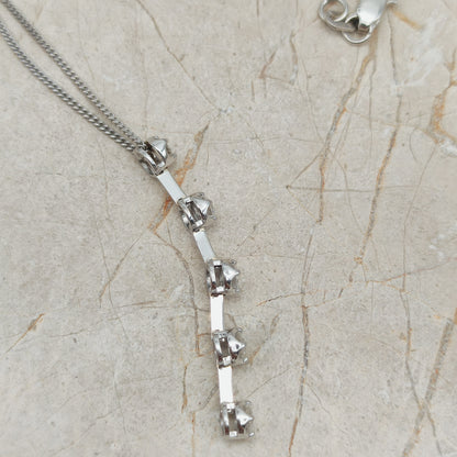 Zijaanzicht van witgouden hanger met verhoogde diamantzettingen