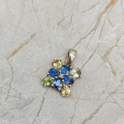 Detail van gouden hanger met ovale saffieren in verschillende kleuren