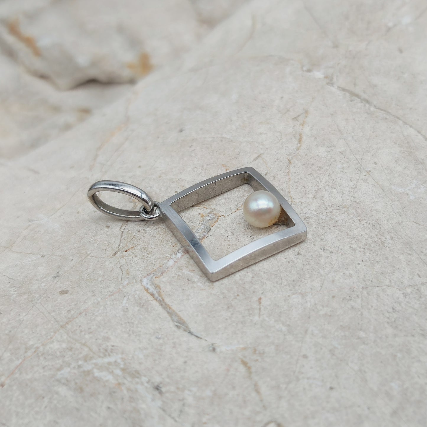 Zijaanzicht van witgouden hanger met Akoya parel en ruim hangeroog