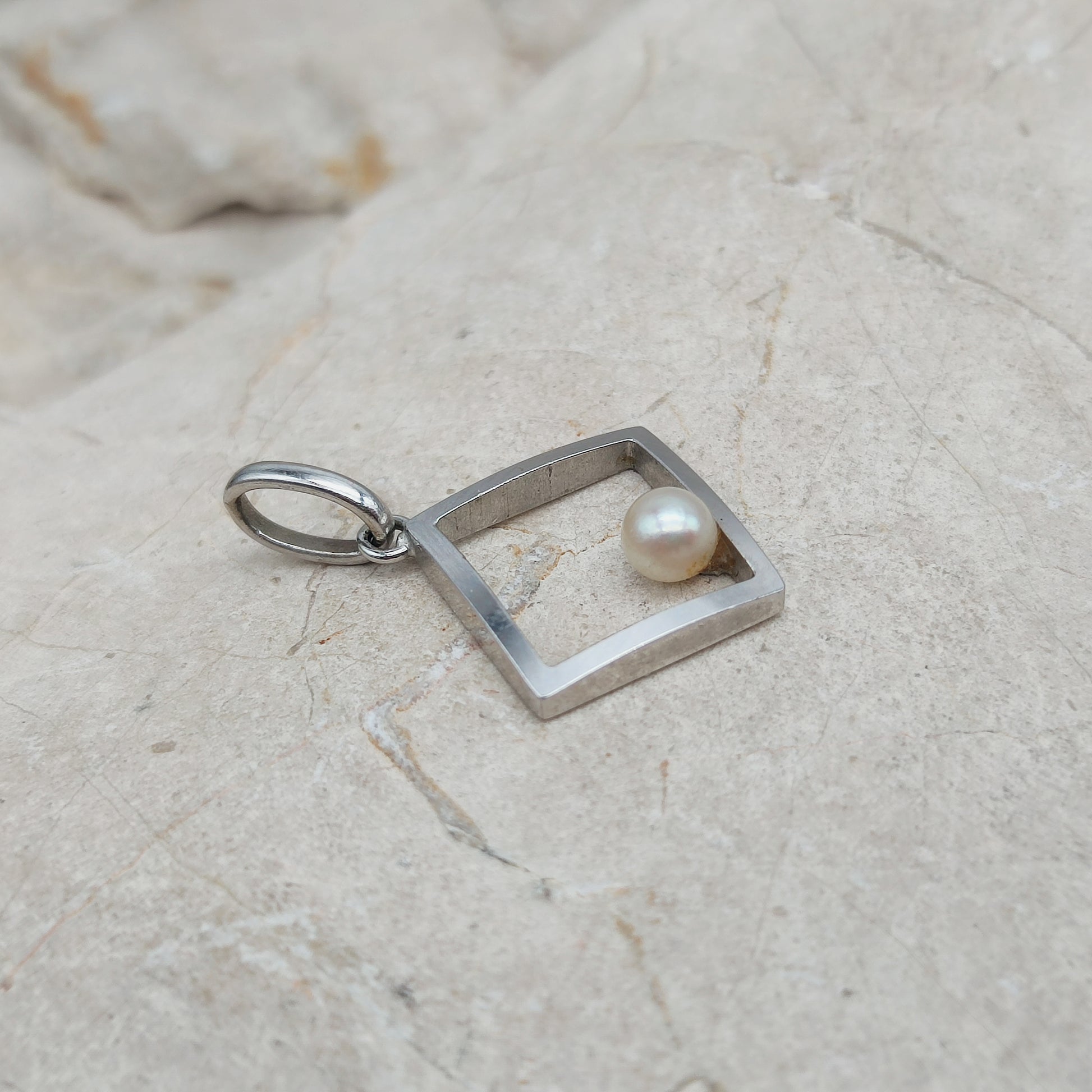Zijaanzicht van witgouden hanger met Akoya parel en ruim hangeroog