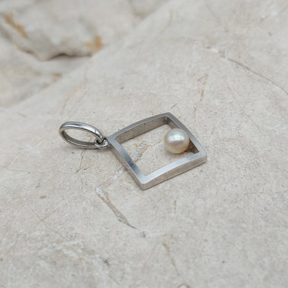 Zijaanzicht van witgouden hanger met Akoya parel en ruim hangeroog