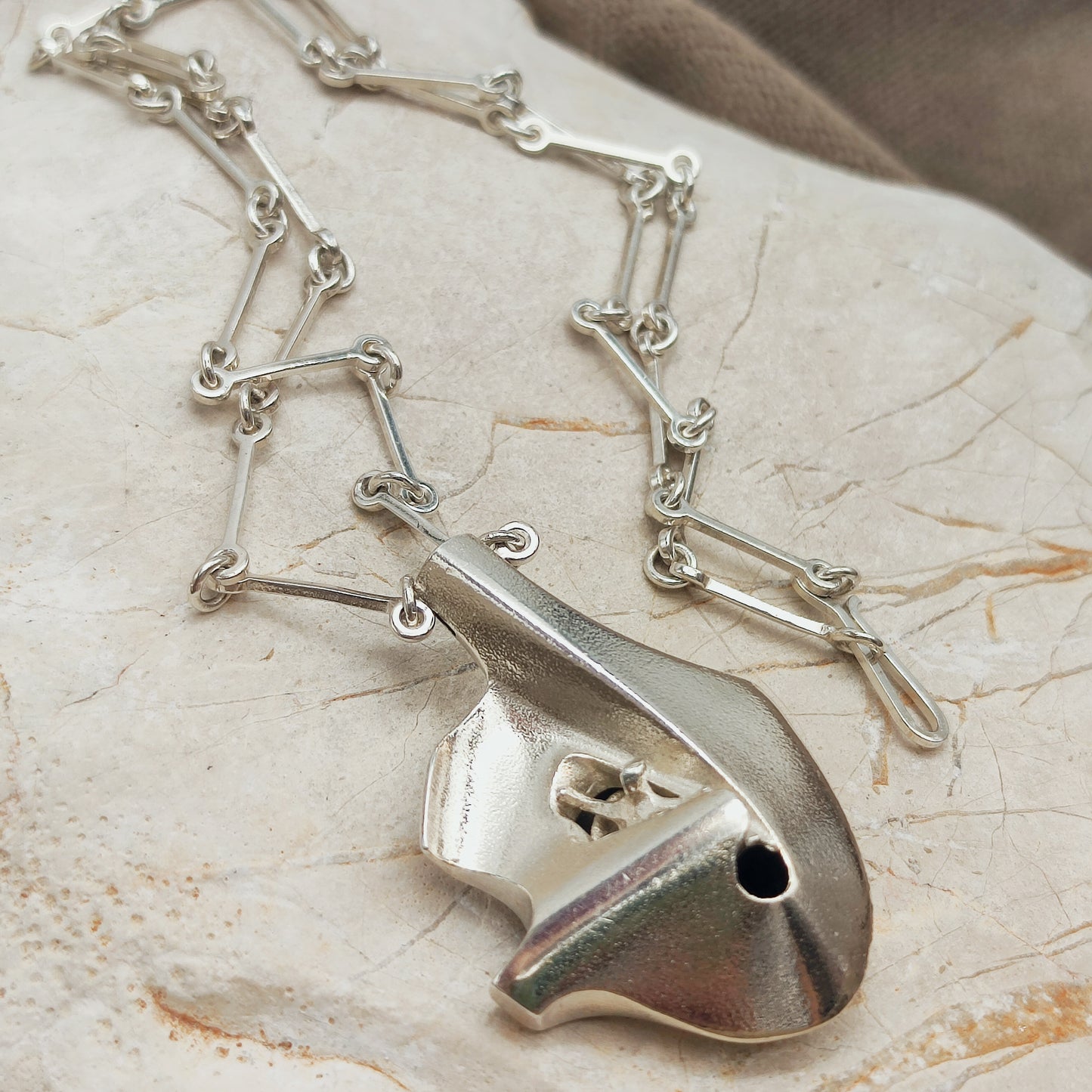 Side view of the three-dimensional sterling silver Auriga pendant