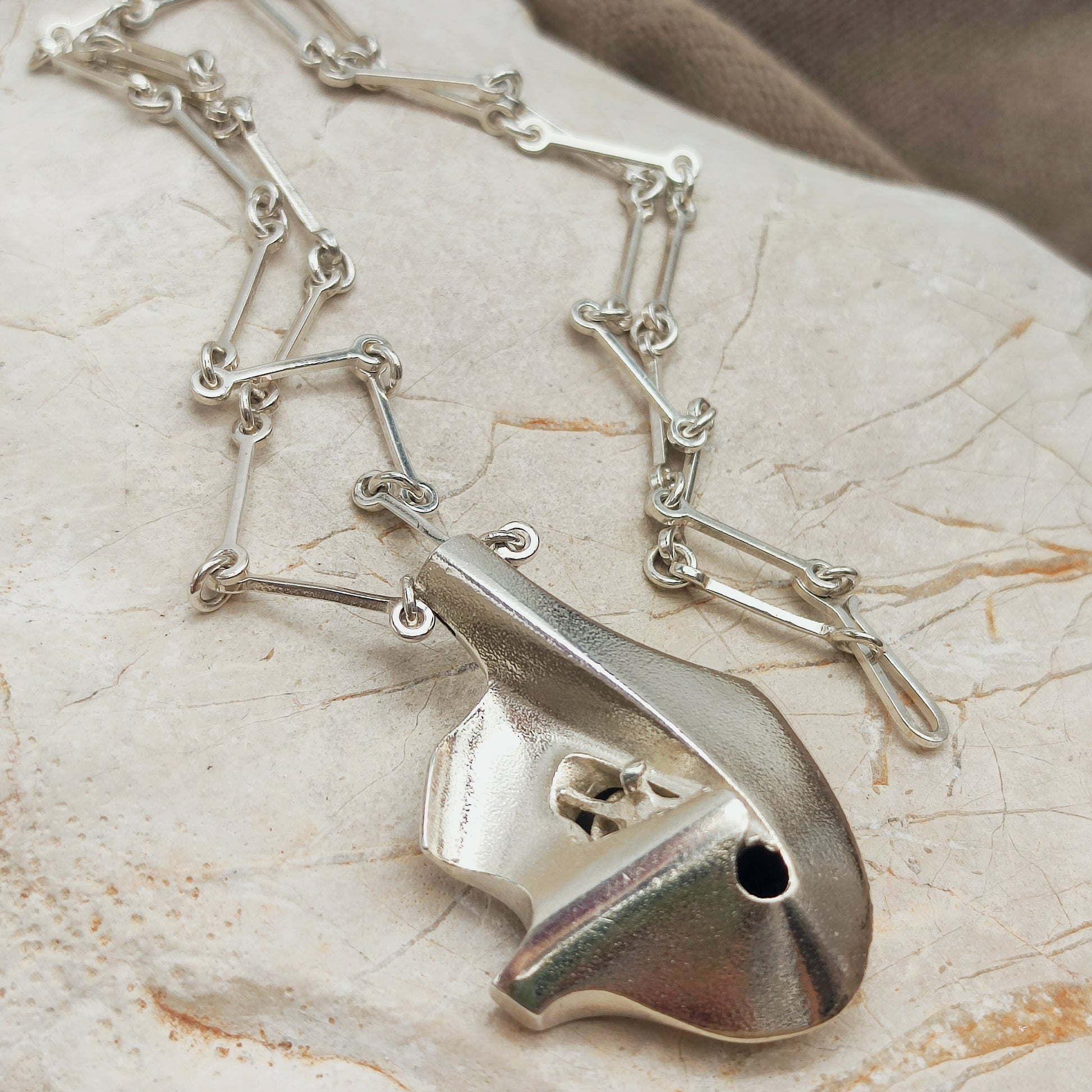 Side view of the three-dimensional sterling silver Auriga pendant