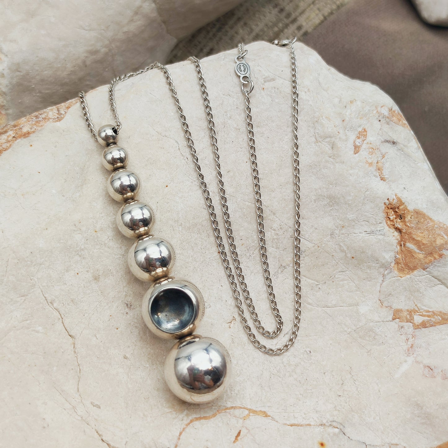 Rotating silver spheres of the Georg Jensen Cave pendant