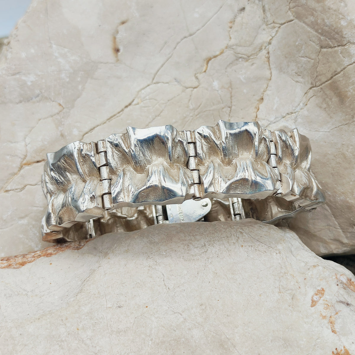 Zware vintage sterling zilveren paneelarmband uit 1972 van Matti J. Hyvärinen voor Sirokoru, met acht diep getextureerde panelen.