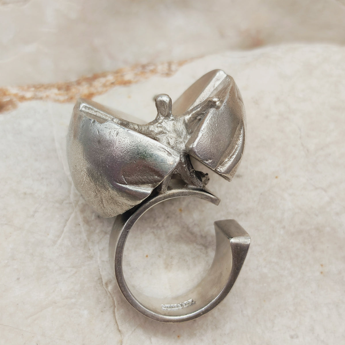 Vintage Lapponia Ikaros-ring uit 1975 van Björn Weckström, met een menselijke figuur tussen twee grote zilveren vleugels.