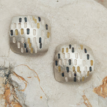 Grote bolle clipoorbellen van Jan Suchodolski in gematteerd 925 zilver, met vergulde en donker geoxideerde rechthoekige accenten.