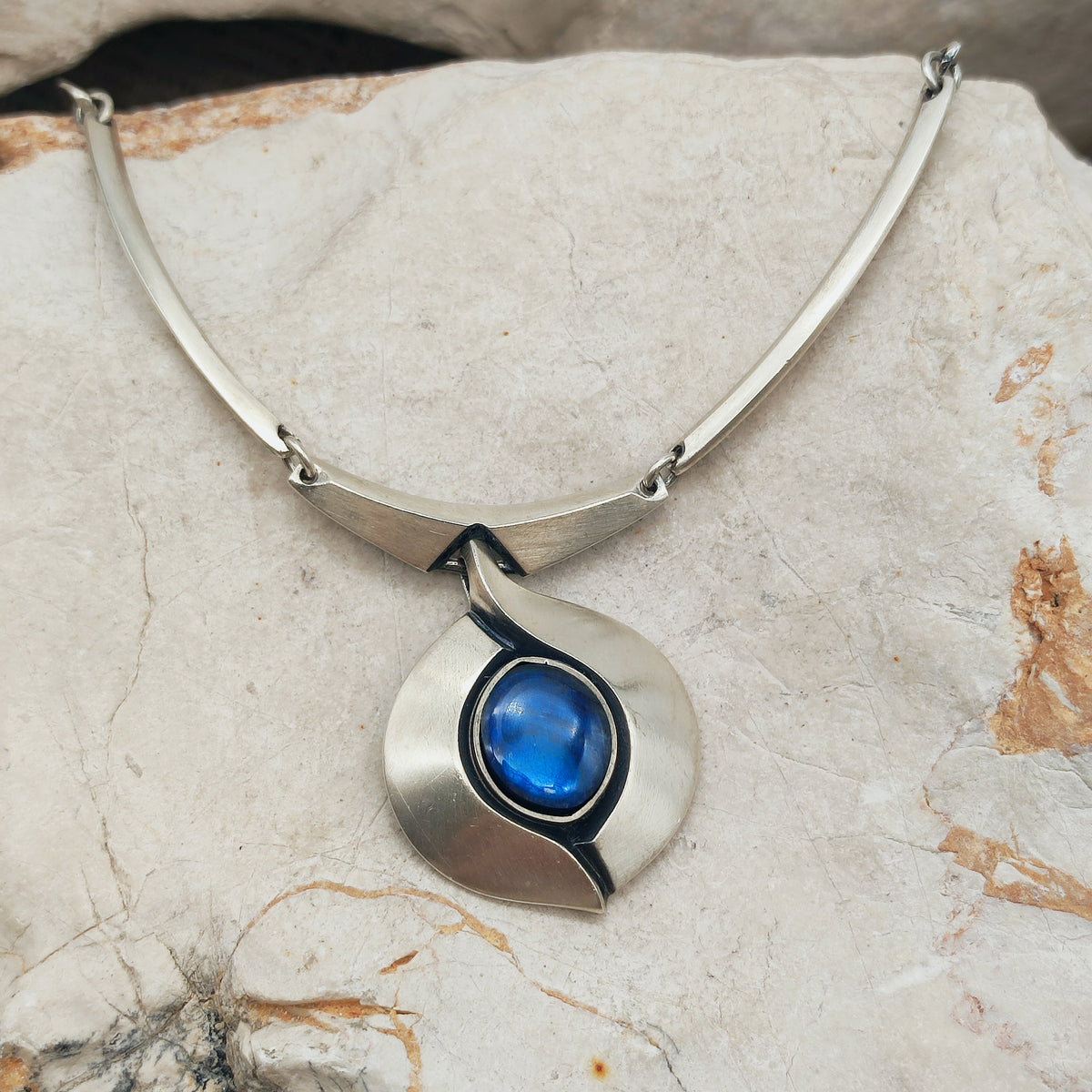 Korte vintage Sirokoru-halsketting van Matti J. Hyvärinen in mat zilver met een vaste hanger en felblauwe ovale spectroliet.
