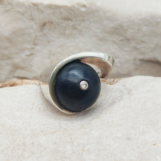 Modernistische sterling zilveren ring met een ovale donkerhouten inzet en een kleine briljant geslepen diamant in het midden.