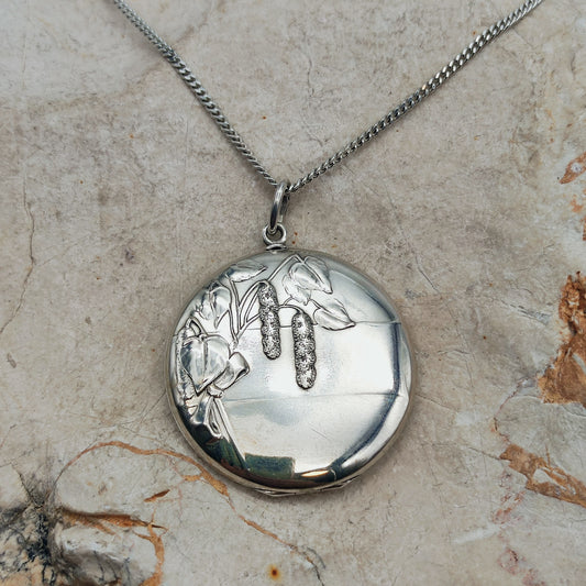 Antiek Art Nouveau-medaillon in 800 zilver met een hazelaartak, bladeren en hangende katjes aan een zilveren ketting.