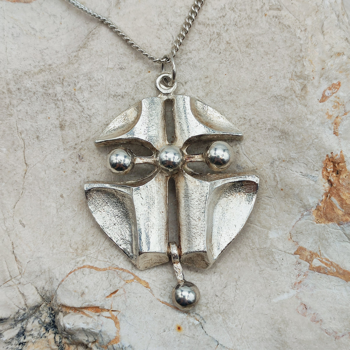 Grote vintage Finse AKT-hanger in zilver met gebogen geometrische vlakken, openingen en vier gladde bollen aan een gourmetketting.